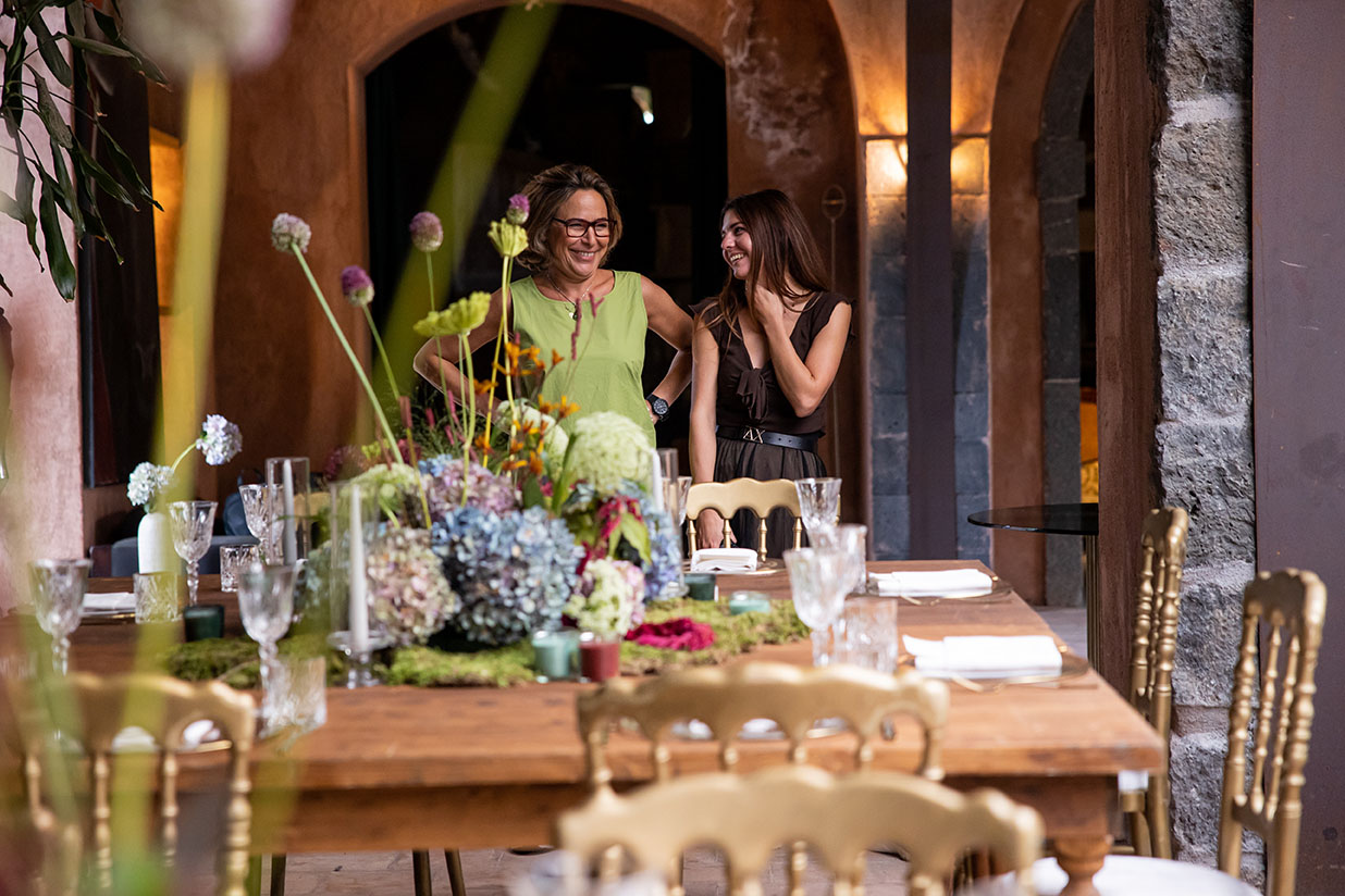 Two people smiling in front of a table